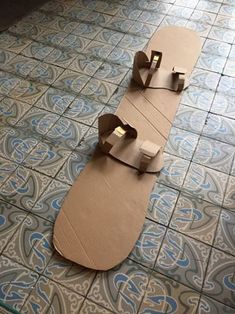 two pieces of cardboard sitting on top of a tiled floor