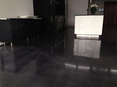 an empty kitchen with black cabinets and white counter tops in the middle of the room