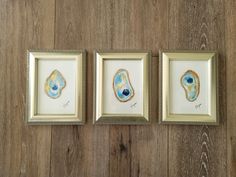 three framed pictures hanging on the wall with blue and yellow designs in them, one has an animal's eye