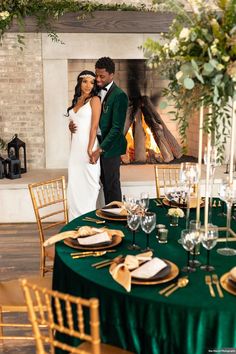 a newly married couple standing next to each other in front of a table set for dinner