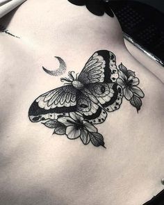 a black and white butterfly tattoo on the side of a woman's stomach,