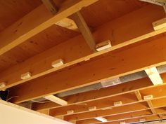 an unfinished ceiling with wooden beams and electrical wires