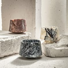 three marble bowls sitting on top of each other in front of some concrete blocks and one is