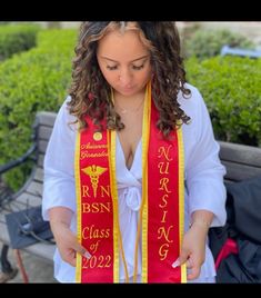 a woman wearing a red and yellow graduation sash