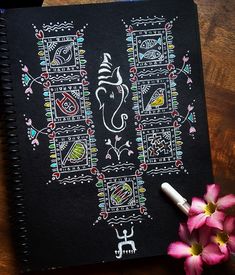 a notebook with an elephant drawn on it next to pink flowers and a white pen