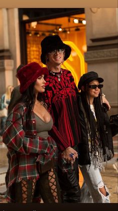 three people dressed in costumes walking down the street