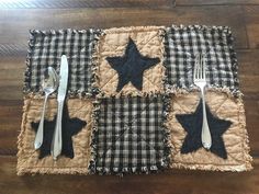 a placemat with black stars on it and silverware in the middle, sitting on a wood floor