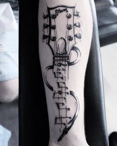 a black and white photo of a guitar tattoo