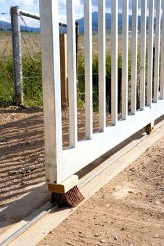 a broom sitting on the ground next to a fence