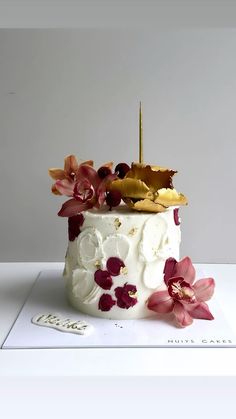 a white cake with red and yellow flowers on it