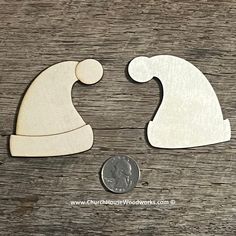 two wooden santa hats next to a penny