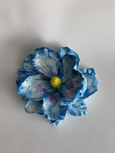 a blue flower sitting on top of a white table