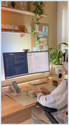 a person sitting at a desk in front of a computer monitor, keyboard and mouse