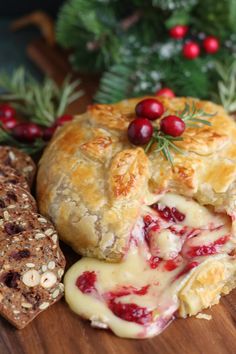 some food is laying out on a cutting board next to christmas decorations and greenery