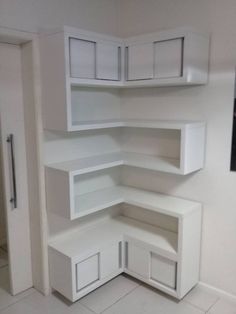 an empty room with white shelves and cupboards