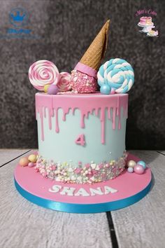 a birthday cake decorated with candy, lollipops and an ice cream cone