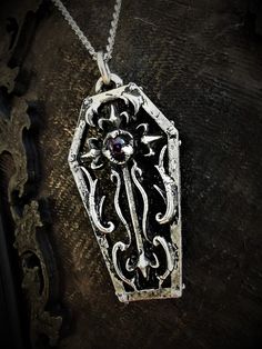 This gothic coffin necklace is an handmade pewter sculpture with a gemstone of your choice This Coffin Pendant is sold with a free 18'' stainless steel chain, if you would like to have a different lenght for the chain, you can write the desired lenght in the private note section when ordering :) The little coffin is 3.5cm top to bottom This Gothic Coffin is a pewter sculpture of my own creation, i create and work the metal by myself at home. The material used is the finest and highest grade hypo Gothic Silver Necklaces With Antique Finish, Silver Gothic Necklaces With Antique Finish, Silver Gothic Necklace With Antique Finish, Halloween Silver Jewelry With Cross Pendant, Silver Cross Pendant Jewelry For Halloween, Gothic Hand Cast Collectible Necklaces, Vintage Engraved Jewelry For Halloween, Gothic Halloween Jewelry With Oxidized Finish, Gothic Oxidized Jewelry For Halloween