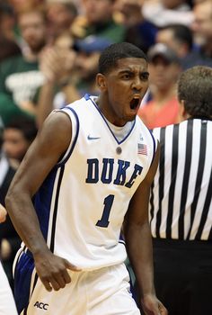 a basketball player with his mouth wide open in front of an official on the court