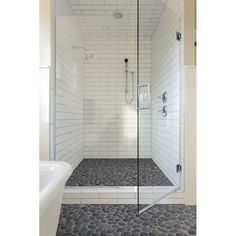 a walk in shower sitting next to a bath tub and a white tiled bathroom floor