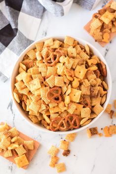 a bowl filled with cheetos sitting on top of a counter next to some crackers