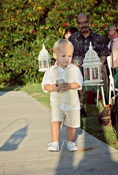 a little boy in white shirt and shorts walking down the sidewalk