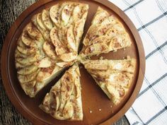 a wooden plate topped with sliced apples on top of a table