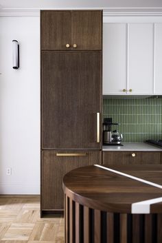 a kitchen with white cabinets and wood floors