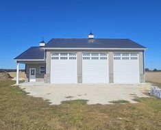 a two car garage sits in the middle of an empty field with no grass on it