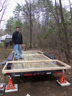 a man is standing on the back of a truck with some wood planks attached to it