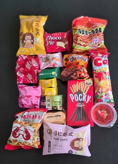 various snacks are laid out on the table together, including candy bars and chips to be eaten