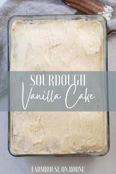 a square cake in a pan with vanilla frosting on top and the words sourdough vanilla cake above it