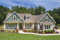 a blue and white house in the middle of a green field with trees behind it