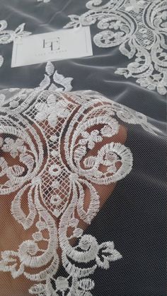 the fabric is white and black with some lace on it's edges, along with a name tag