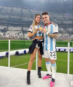 a man and woman standing next to each other at a soccer game