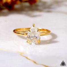 a yellow gold ring with a white diamond