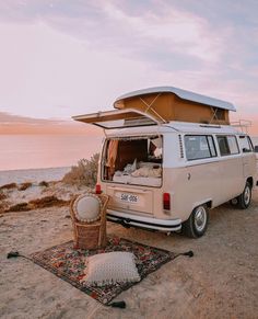 an old vw van parked on the beach with its roof open and it's bed pulled up