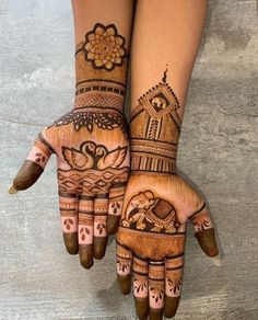 two hands with henna tattoos on them