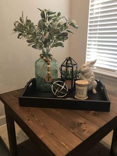 a wooden table topped with a tray filled with plants