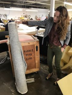 a woman standing next to a pile of furniture