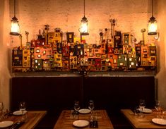 a restaurant with wooden tables and chairs in front of a large wall covered with pictures