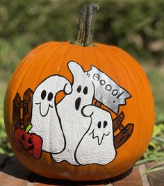 a pumpkin with two ghost faces painted on it