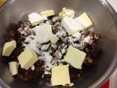 a metal bowl filled with lots of different types of cheese and other food items on top of it