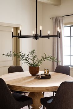 a wooden table with chairs around it and a potted plant on the table top