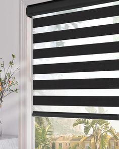 a black and white striped blind in front of a window with flowers on the windowsill