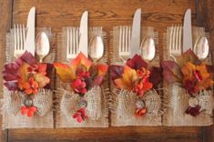 four forks are lined up on burlap and decorated with autumn leaves, flowers and berries