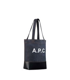 A.P.C. tote bag. - Tote bag in Japanese denim.- Two large handles. May be carried on shoulder or by hand.- Wide band in smooth leather on bottom of bag.- Reinforced base.- Interior zip pocket.- Large A.P.C. logo in front.- Caramel topstitching on the denim.- Small version of the Axelle tote bag. Coated Canvas Bucket Bag Tote For Errands, Coated Canvas Tote Bucket Bag, Shopping Bucket Bag With Coated Canvas, Coated Canvas Bucket Bag For Shopping, Medium Shoulder Bag With Large Capacity For Shopping, Medium Shoulder Bag With Leather Handles, Modern Medium Shoulder Bag For Errands, Medium Canvas Shoulder Bag For Shopping, Medium Satchel For Shopping