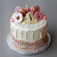 a birthday cake decorated with donuts and sprinkles