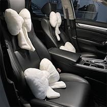 two stuffed animals sitting in the front seats of a car with black leather trims