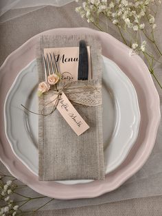 a place setting with napkins, forks and flowers on the table for an elegant dinner