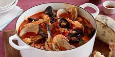 a pot filled with clams and bread on top of a table